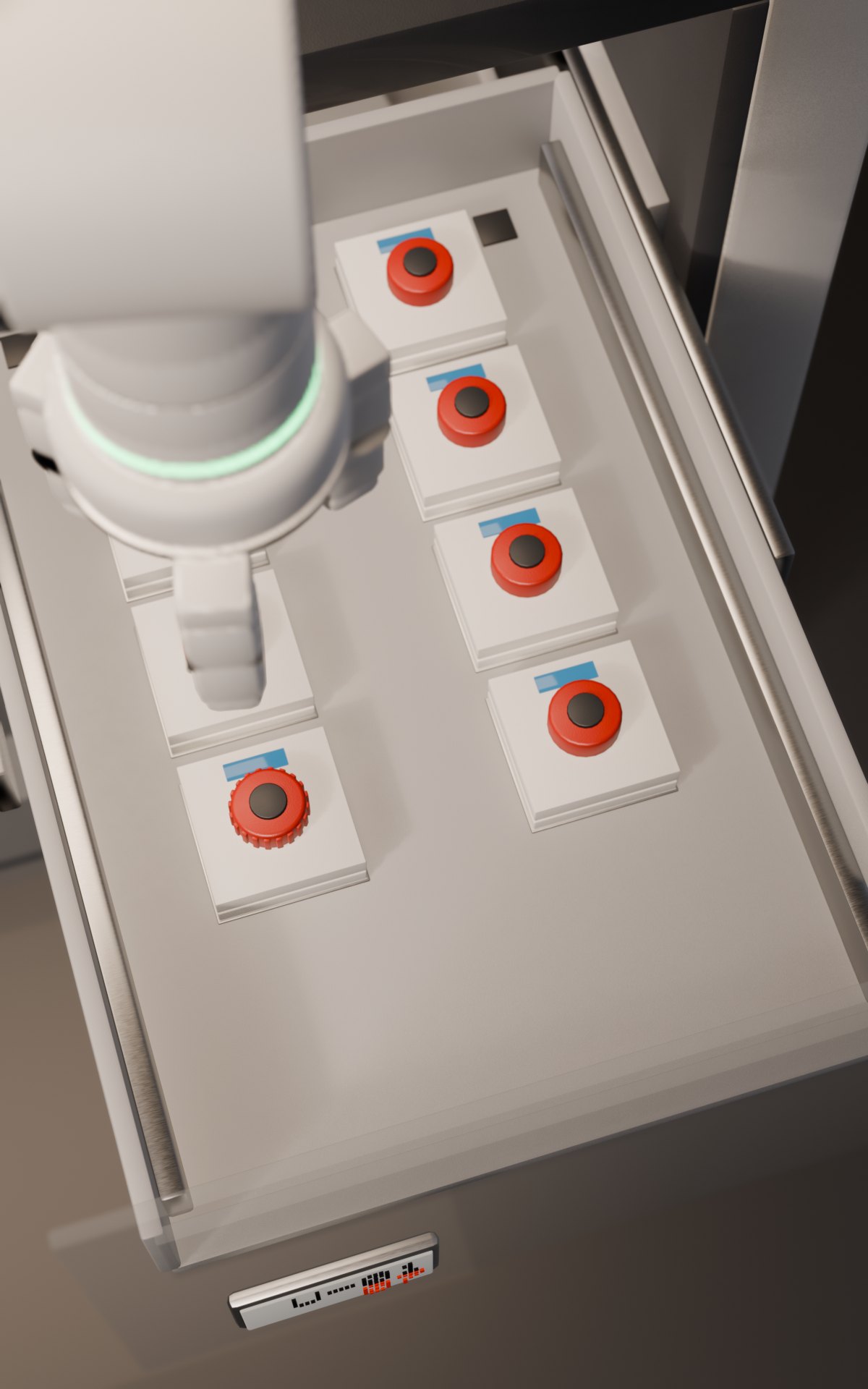 Looking down into the pulled-out output drawer as the arm files a finished controller